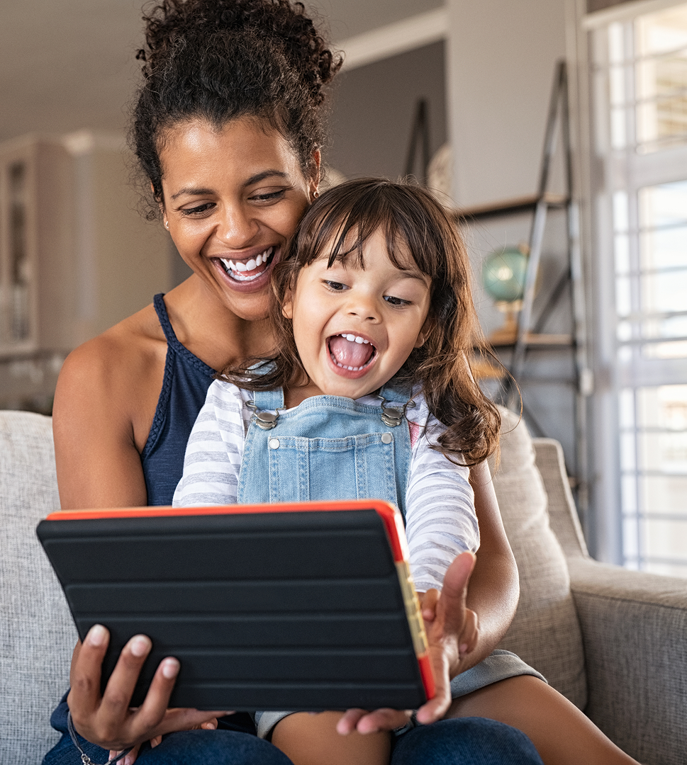 Parent and child playing game on tablet and smiling
