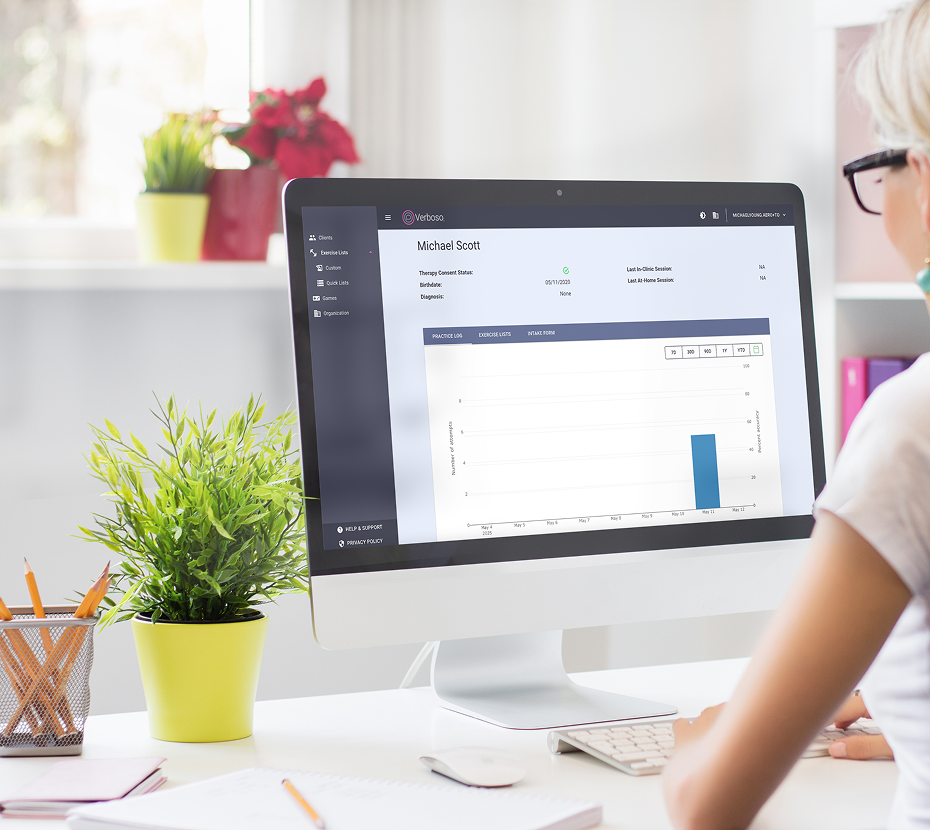 Person sitting at computer using Verboso Enterprise Portal showing clients and progress.